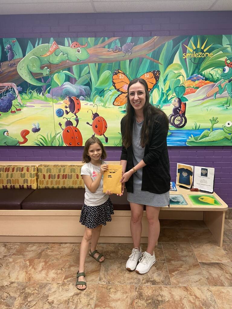 Maddie provides a $200 donation to Five Counties.